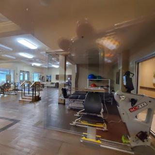 A view of a rehabilitation space equipped with various exercise tools and facilities for physical therapy.