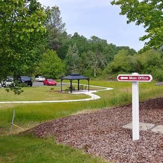 A scenic rest area with a picnic shelter and parking, surrounded by lush greenery.