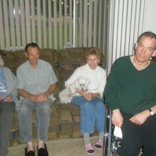 A group of people sitting indoors in a living room setting.