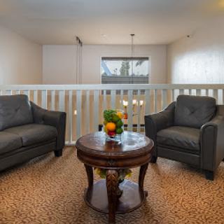 A cozy living room setup featuring two stylish chairs and a coffee table adorned with fresh fruit.