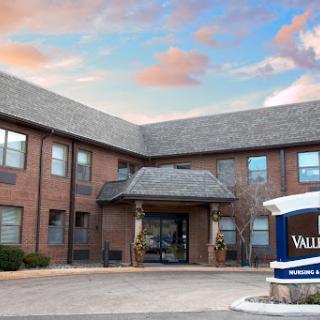 Front view of a residential building with landscaped entrance and sign.