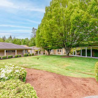 A beautiful house with a well-maintained garden and lush green lawn.