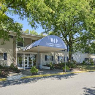 A welcoming entrance to a facility surrounded by lush greenery.
