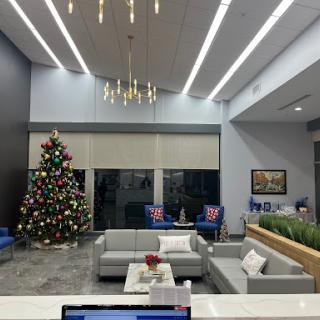A stylish modern lobby decorated for the holiday season, featuring a beautifully adorned Christmas tree and comfortable seating arrangements.