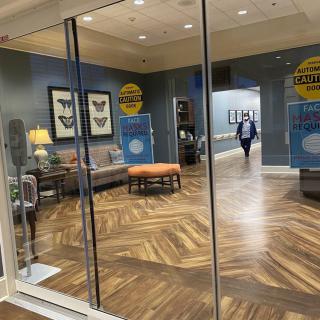 A welcoming lobby area with seating and decorative elements behind glass doors.
