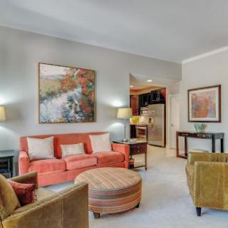 A cozy living room with a warm color palette, featuring a coral sofa, abstract artwork, and ambient lighting.