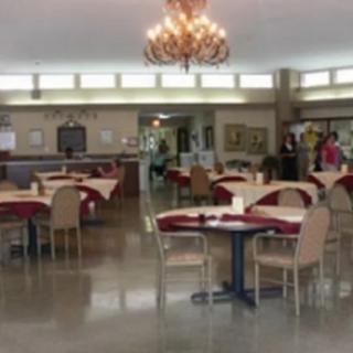 An empty dining area with arranged tables and a chandelier.