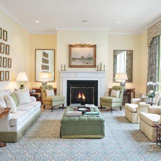 A cozy and traditional living room with a fireplace, comfortable seating, and tasteful decor.