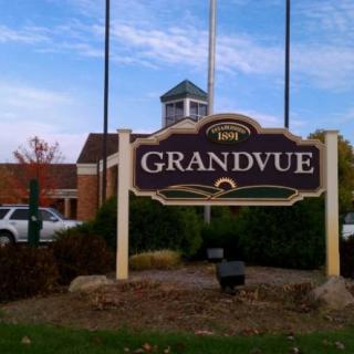 Sign for Grandvue in front of a brick building under a blue sky.