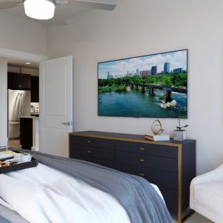 A modern, minimalist bedroom featuring a wall-mounted television and sleek furnishings.