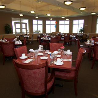 A spacious dining room with multiple tables set for guests.