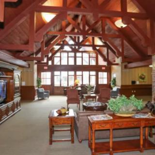 Spacious living room with high wooden beam ceilings and elegant furniture.