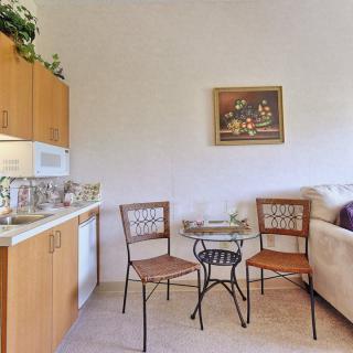 A small kitchen area with a table, chairs, and a sofa.