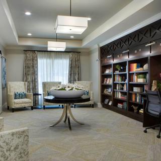 A modern, cozy library room with bookshelves, comfortable seating, and elegant lighting.