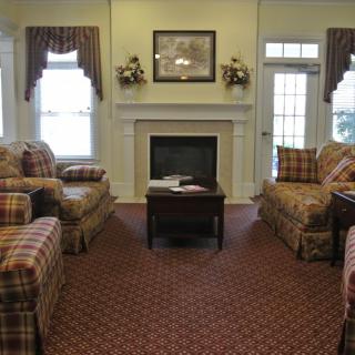 A traditional living room featuring plaid furniture and a fireplace.