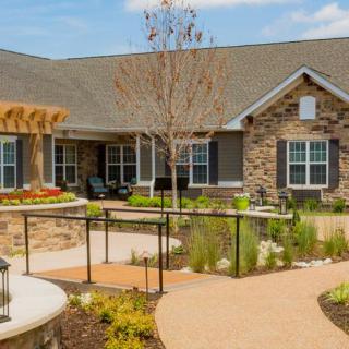 A beautifully landscaped single-story house with a well-maintained garden and pathway.