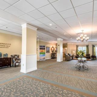 A spacious and elegantly decorated lobby with comfortable seating areas, a chandelier, and art on the walls.