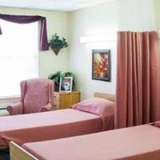 A cozy bedroom with two beds, a comfortable chair, and decorative curtains.