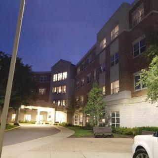 A quiet evening view of a residential building, illuminated against the night sky.