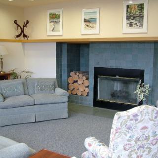 A cozy living room with a fireplace, sofas, and decorative artwork on the wall.