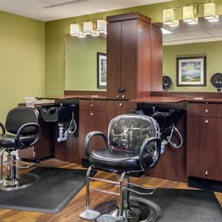 A modern hair salon interior with two styling chairs and mirrors.