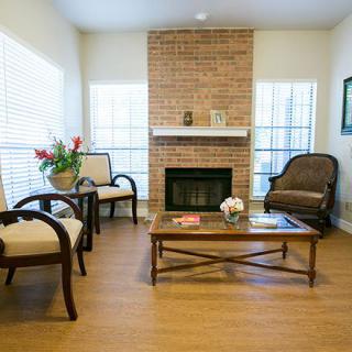 A cozy living room with a brick fireplace and elegant furnishings.