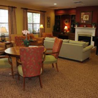 A cozy living room with a dining area, featuring comfortable seating, a fireplace, and warm lighting.