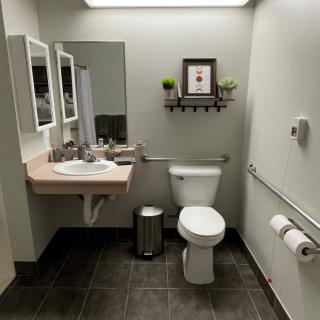 A clean and organized bathroom with a sink, mirror, and toilet.