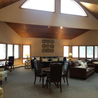 A spacious living room featuring ample seating and large windows allowing natural light to flood in.