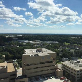 Aerial view of city buildings under a partly cloudy sky.