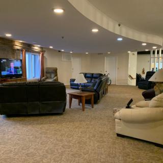 A spacious basement living room with comfortable seating and a TV.