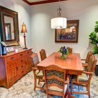 A cozy dining room with a wooden table and chairs, complemented by elegant decor and artwork.