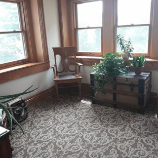 A cozy corner with a chair and plants by the window.