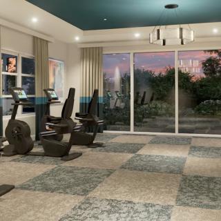 A modern gym room with exercise equipment and large windows overlooking a scenic view.