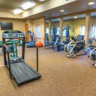 A gym with various exercise equipment including treadmills and elliptical machines.