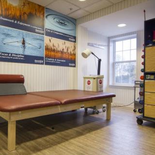A well-organized physiotherapy room featuring a treatment bed and various therapeutic equipment.