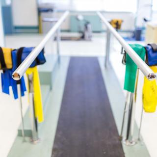 A rehabilitation setup featuring parallel bars and resistance bands in a physical therapy center.