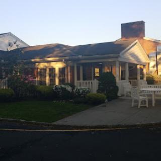 A charming house with a well-kept garden, basking in the warm glow of sunset.