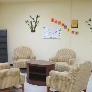 A cozy waiting room with comfortable chairs and decorative wall elements.