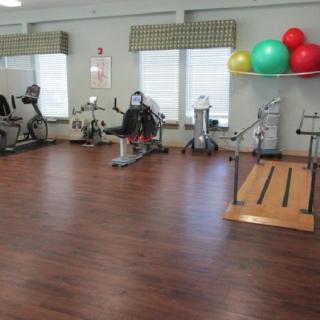 A gym with various exercise equipment and colorful exercise balls.