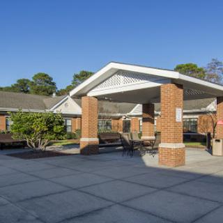 A welcoming entrance to a modern facility, featuring a clean design and well-maintained landscaping.