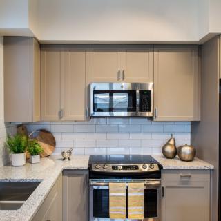 A modern kitchen with stainless steel appliances and neutral-toned cabinets.