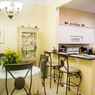 Cozy dining area adjacent to a kitchen with bar stools and elegant decor.