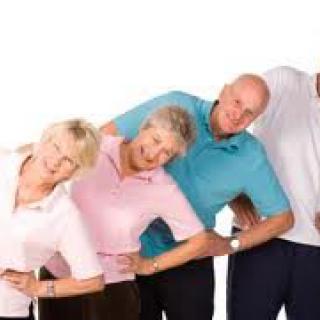 A group of seniors engaging in a light exercise activity together.