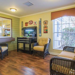A cozy living room with wicker furniture, a fish tank, and decorative wall art.