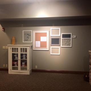 A cozy interior space with wall art and a small cabinet.