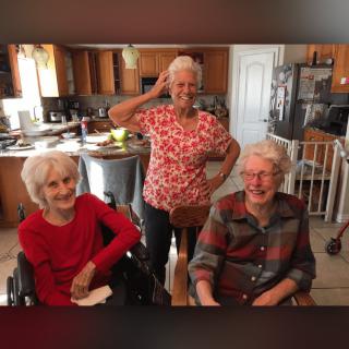 Three seniors enjoying time together in a kitchen setting.