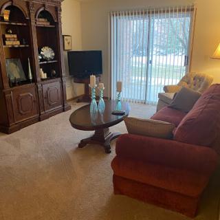 A cozy living room setup featuring a red sofa, a coffee table, and a television unit.