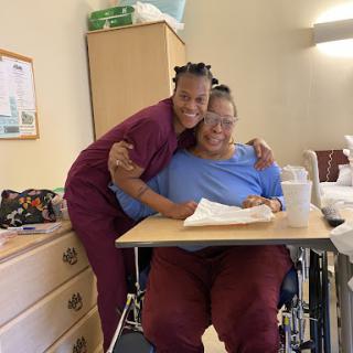 A warm moment between a caregiver and patient, showcasing compassion and support in a hospital setting.