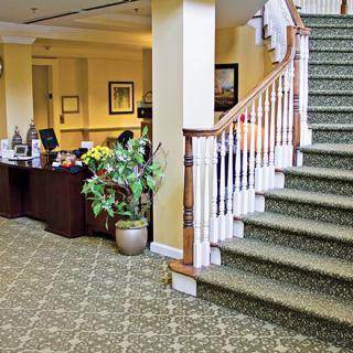 A lobby area with a reception desk and carpeted staircase.